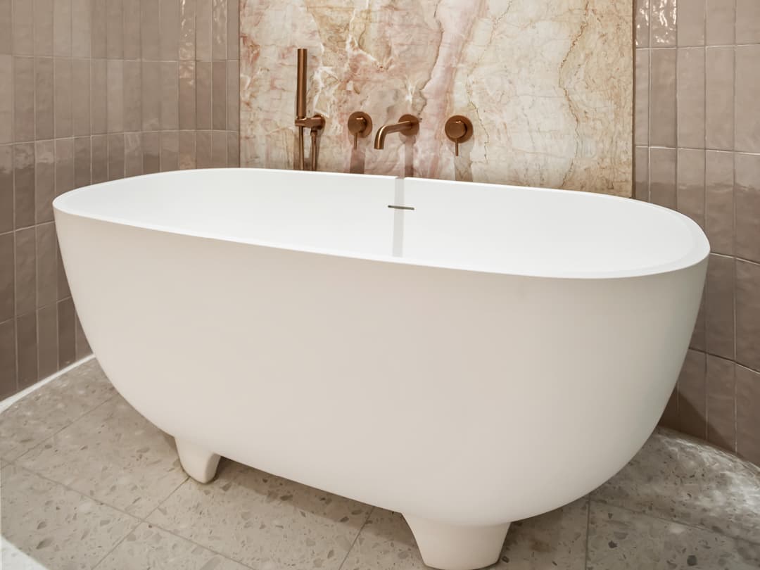 Luxury freestanding bath with marble feature wall and bronze fixtures