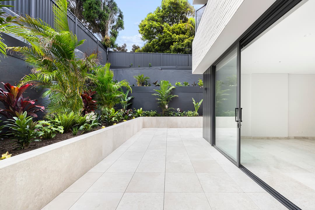 Outdoor terrace with large format tiles and garden privacy